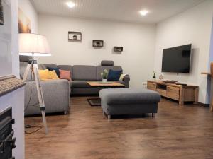 a living room with a couch and a tv at Dat tweete Tohuus in Soltau