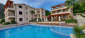 a large swimming pool in front of two buildings at Bellezza Residence & Spa Kotor in Donji Morinj