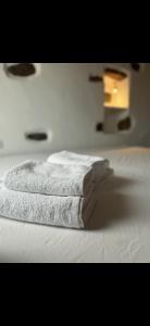 a stack of towels sitting on top of a bed at VR Chora Apartments in Serifos Chora