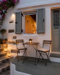 a table and two chairs in front of a building at VR Chora Apartments in Serifos Chora