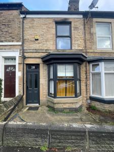 a brick house with a black door and windows at Cozy House in Crookes in Walkly