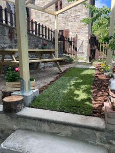 a picnic table and bench in a yard with grass at Quercus La Baita in La Verna