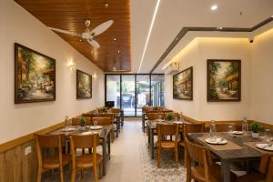 a restaurant with tables and chairs and paintings on the walls at Hotel West Residency Delhi Airport in New Delhi