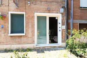 a door of a brick building with a window at Flow Urban Living by DiffeRent in Ferrara