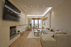 a living room with a couch and a tv at Elegant Villa In Vari With Private Pool in Vari