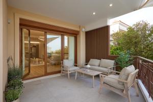a patio with a couch and chairs on a balcony at Elegant Villa In Vari With Private Pool in Vari