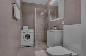 a bathroom with a washing machine and a washer at Nordheim studio apartment in Tromsø