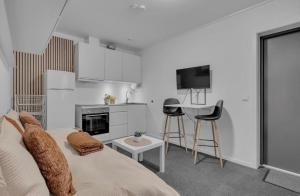 a living room with a couch and a kitchen at Nordheim studio apartment in Tromsø