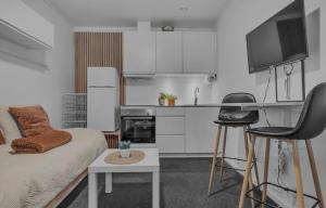 a living room with a couch and a kitchen at Nordheim studio apartment in Tromsø