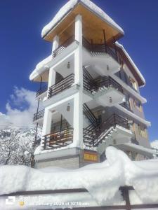 a building with snow on the ground in front of it at The Snow Rock in Palchān