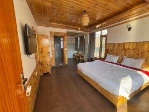 a bedroom with a bed and a television in it at The Snow Rock in Palchān