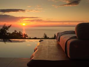 a bed sitting next to a pool with a sunset at Horizon Collection in Agios Nikolaos