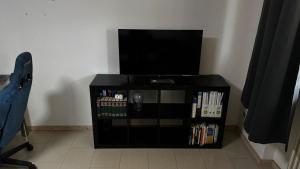 a black stand with a flat screen tv and books at Luki's Apartment in Horn-Bad Meinberg