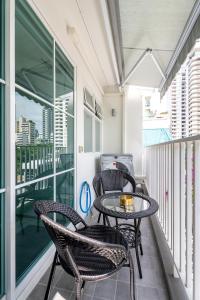 a balcony with two chairs and a table on a balcony at Mac's House in Bangkok