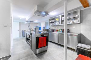 a kitchen with stainless steel appliances and a red oven at ALPENHOF Mountain Lodge in Stechelberg