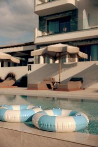 a swimming pool with two inflatables in the water at La Brise Luxury Suites in Nea Peramos +51 photos