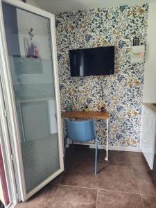 a room with a desk and a television on a wall at Studio chaleureux sans-visà-vis in Vernon