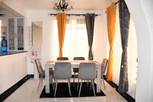 a dining room with a table and chairs at Progressive Success Residency in Juja