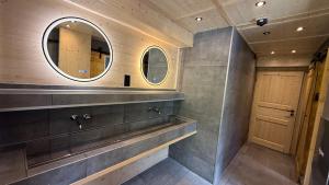 a bathroom with two mirrors and a wooden door at ALPENHOF Mountain Lodge in Stechelberg