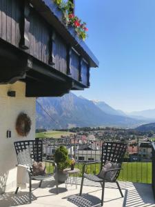 a patio with chairs and a view of a mountain at Huber - Das Tiroler B&B in Oberperfuss