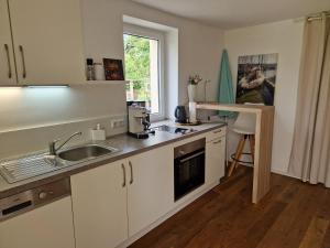 a kitchen with white cabinets and a sink and a window at Fewo Simone - Überlingen City - in Überlingen