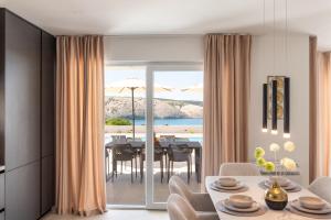 a dining room with a table and a view of the ocean at Villa Amarea in Lopar