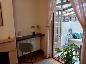 a room with a table and a chair and a window at Railmans Rest in Faversham