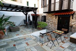 a patio with chairs and a table and a building at The Dream House Skiathos in Skiathos +12 photos