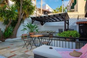 a patio with a couch and a table and chairs at The Dream House Skiathos in Skiathos