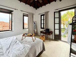 a bedroom with a bed and a desk and windows at The Dream House Skiathos in Skiathos