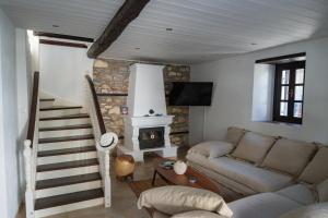 a living room with a couch and a fireplace at The Dream House Skiathos in Skiathos