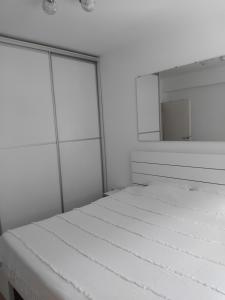 a white room with a bed and a mirror at Zvezdica in Užice