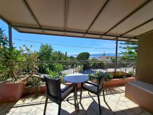 a patio with a table and chairs on a balcony at Stefanos Studios in Lassi