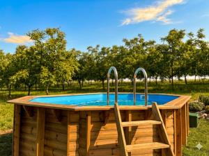 a wooden hot tub with two chairs next to it at Gîte La Chaumière avec Piscine in Nailhac