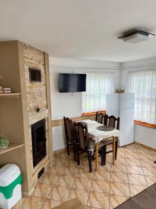a kitchen and dining room with a table and a fireplace at Casuta-Maria-Kisház in Sovata