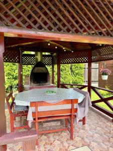 a patio with a table and an outdoor oven at Casuta-Maria-Kisház in Sovata