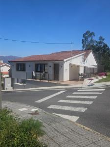a white building with a crosswalk on a street at Terraza del atardecer in Vilar