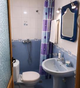 a blue bathroom with a toilet and a sink at Villa Nano in Berat +30 photos