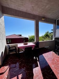 a dining room with a table and two large windows at Guest House in Sarpi in Batumi