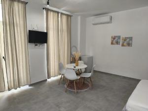 a room with a table and chairs and a bed at Melina Rooms in Dhërmi