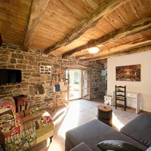 a living room with a stone wall at Kuća Zanetta sa bazenom in Buzet