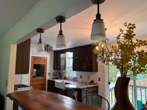 a kitchen with a wooden table and some lights at Eclectic & Fun Custom Home in Shawnee