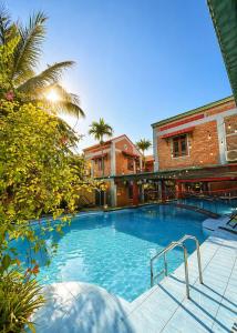 a large swimming pool in a building with trees at Gecko Backpackers Hostel in Ninh Binh