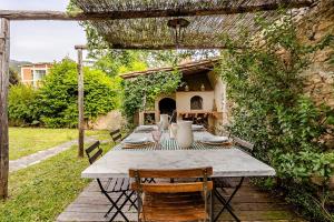 a table and chairs sitting under a pergola at House on the river in Calci