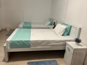 a bedroom with two beds with blue and white sheets at Nimro Luxury Residence in Ragama
