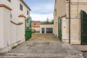an alley with green gates in a building at House on the river in Calci