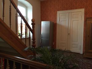 - un réfrigérateur dans une chambre avec un escalier dans l'établissement Pension Gutshaus, à Halle-sur-Saale