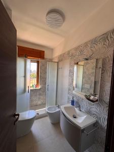 a bathroom with a sink and a tub and a toilet at Vitti Apartment in Nettuno +43 photos