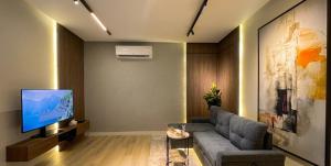 a living room with a couch and a television at هابي رومز - شقق فندقية في الخبر in Al Khobar