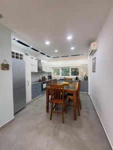 a kitchen with a wooden table and chairs in it at Vila Eva Lalz in Draç
